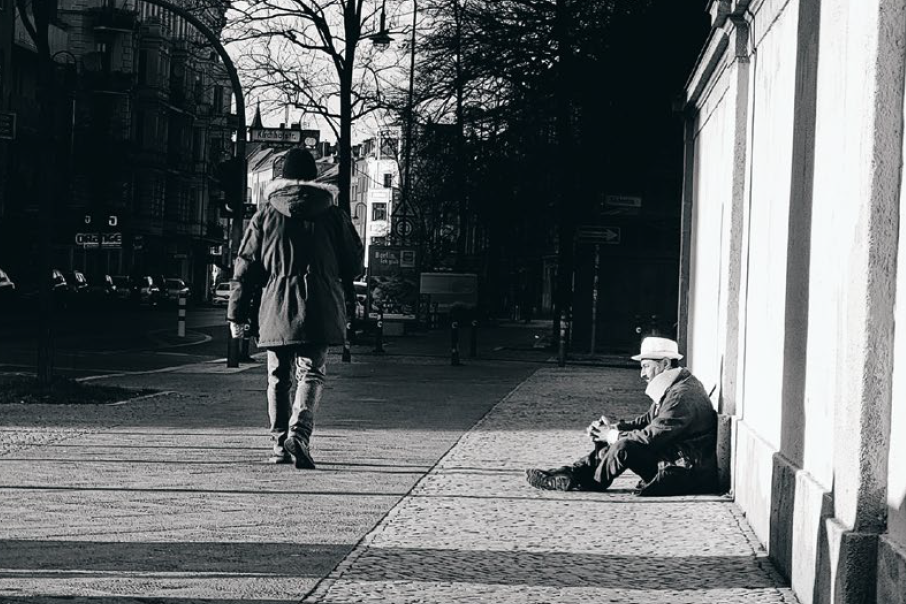 Wohnungsloser sitzt auf der Straße