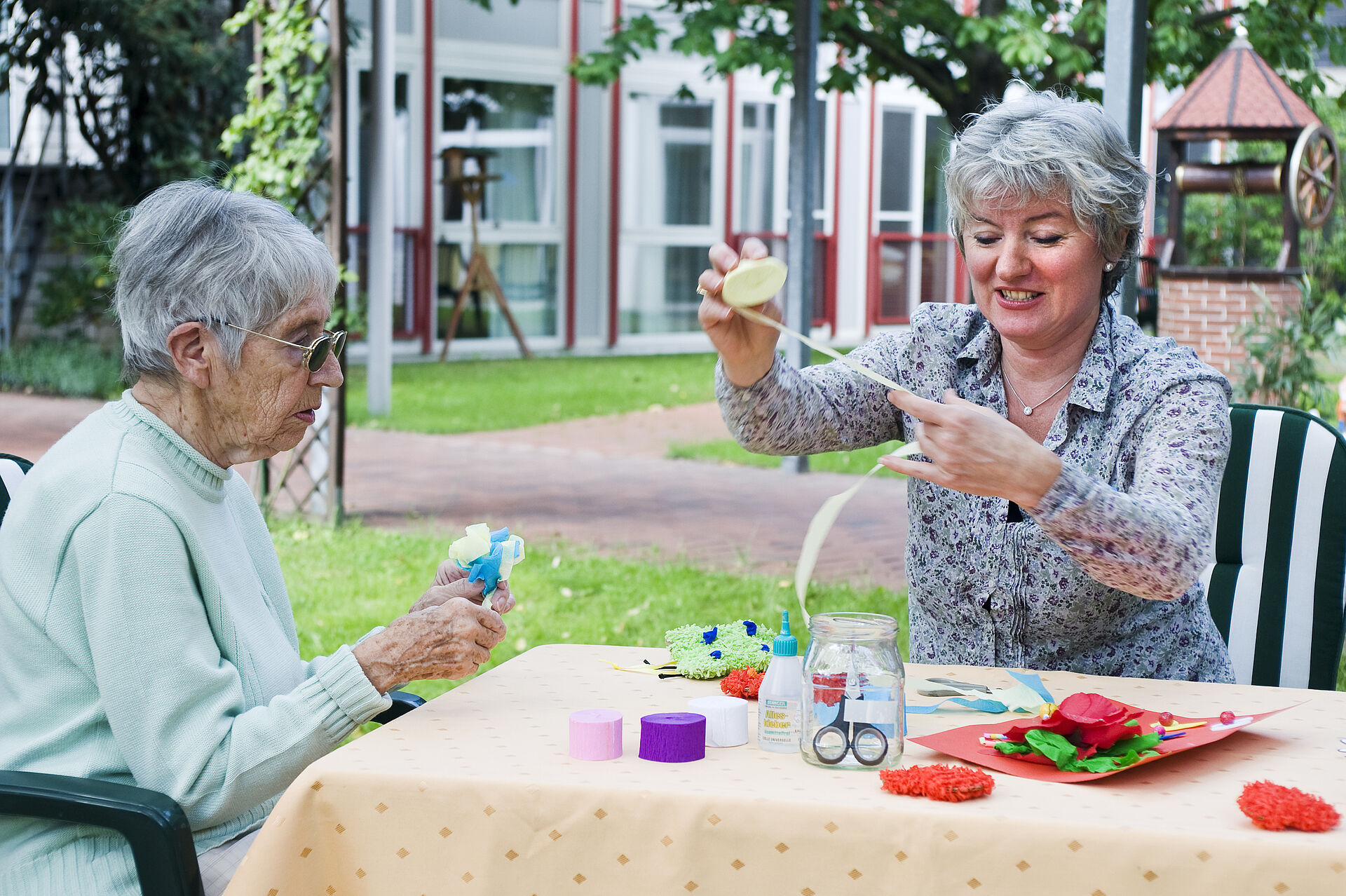 Bewohnerinnen basteln im Garten des Pflegeheims