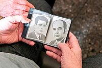 Mann schaut alte Bilder an