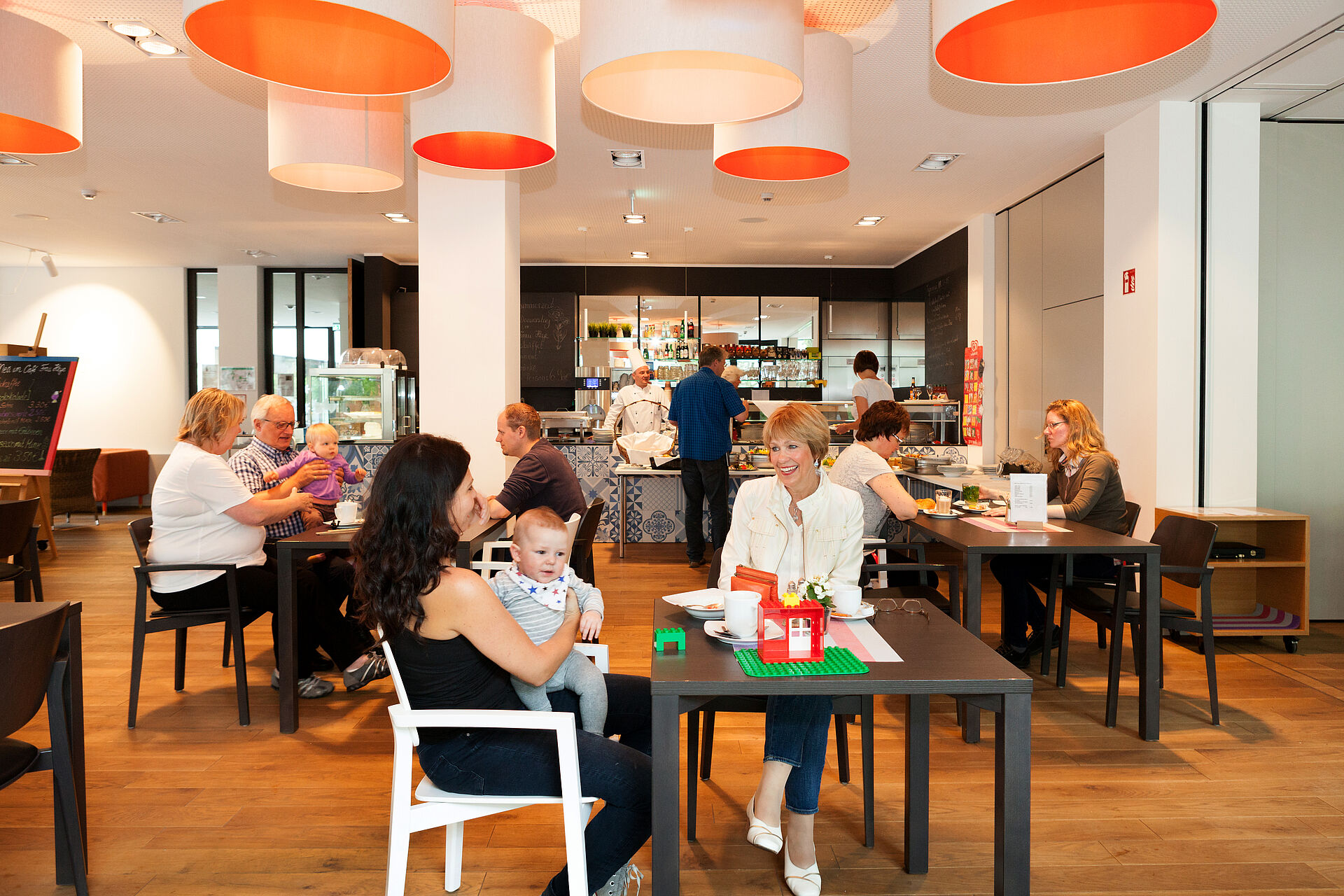 Bewohnerinnen und Nachbarn sitzen im Cafe Heye des Ferdinand-Heye-Hauses