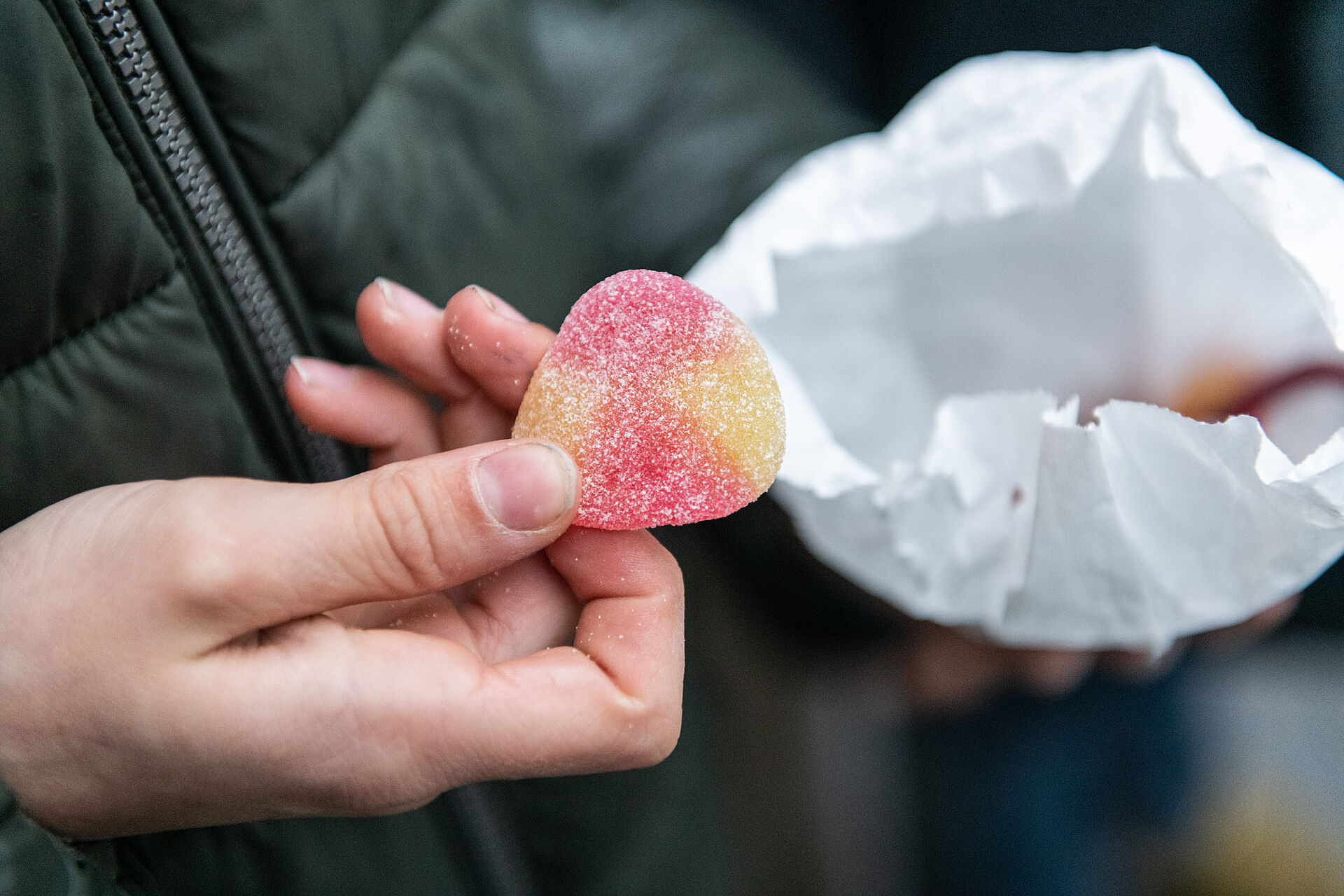 Ein Junge holt einen Gummi-Pfirsich aus seiner süßen Tüte