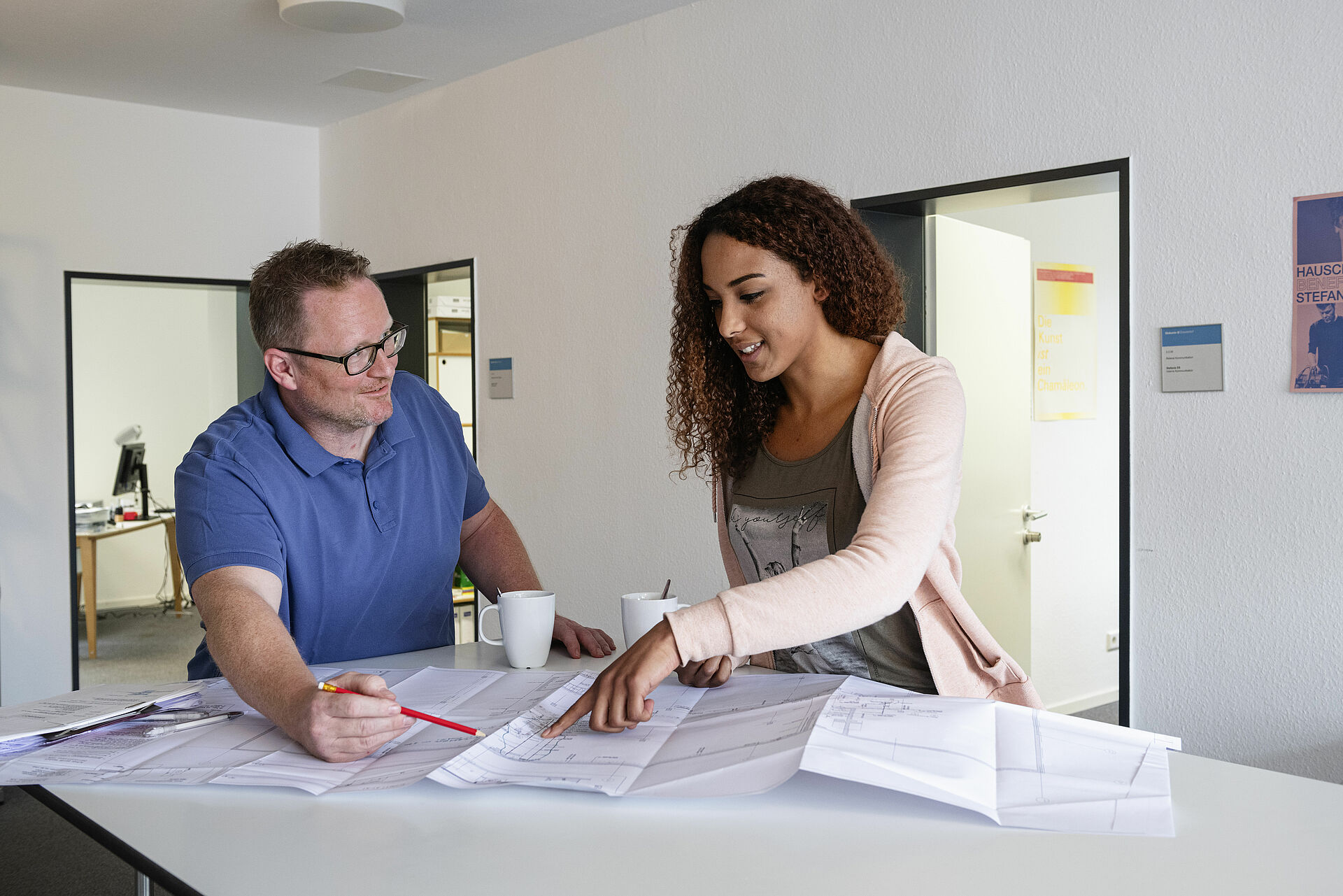 Zwei Verwaltungsmitarbeitende bei der Arbeit