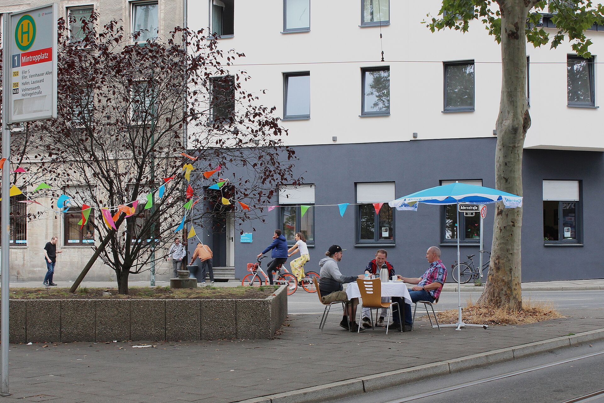 Wohnungslose Menschen picknicken vor dem café pur. 