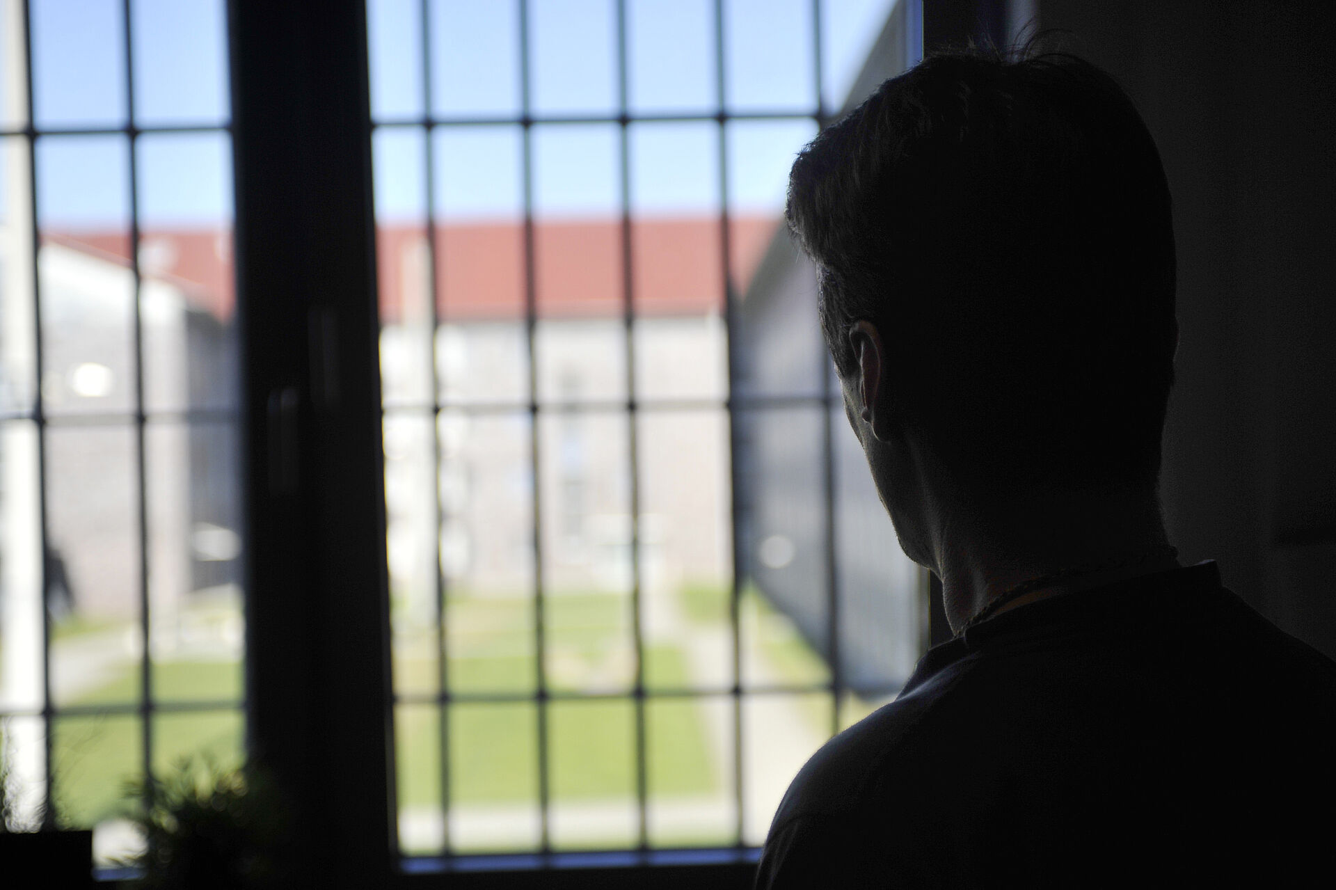 Ein Gefangener schaut aus seiner Zelle