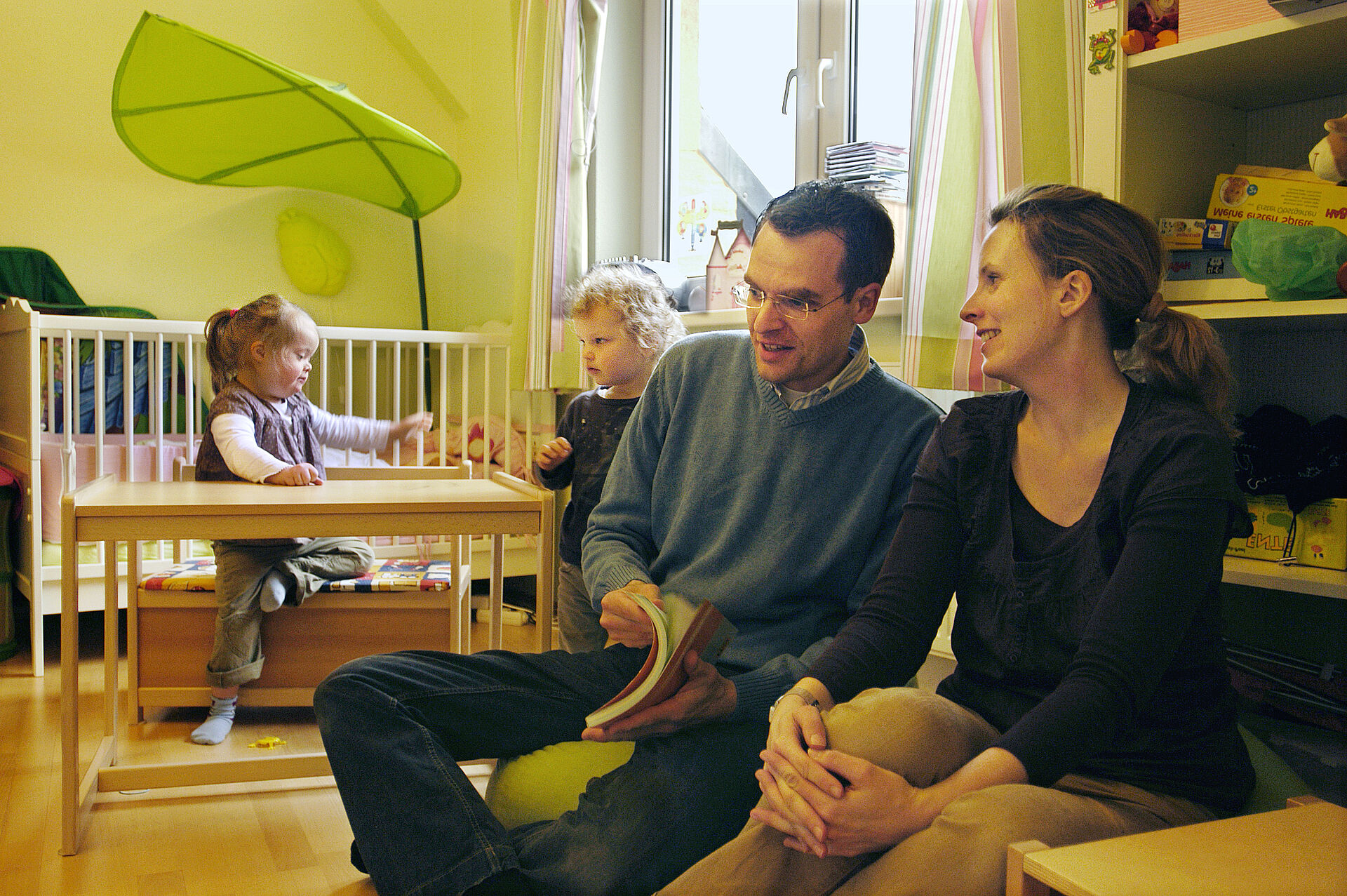 Eltern beraten sich, während ihre Kinder im Hintergrund spielen