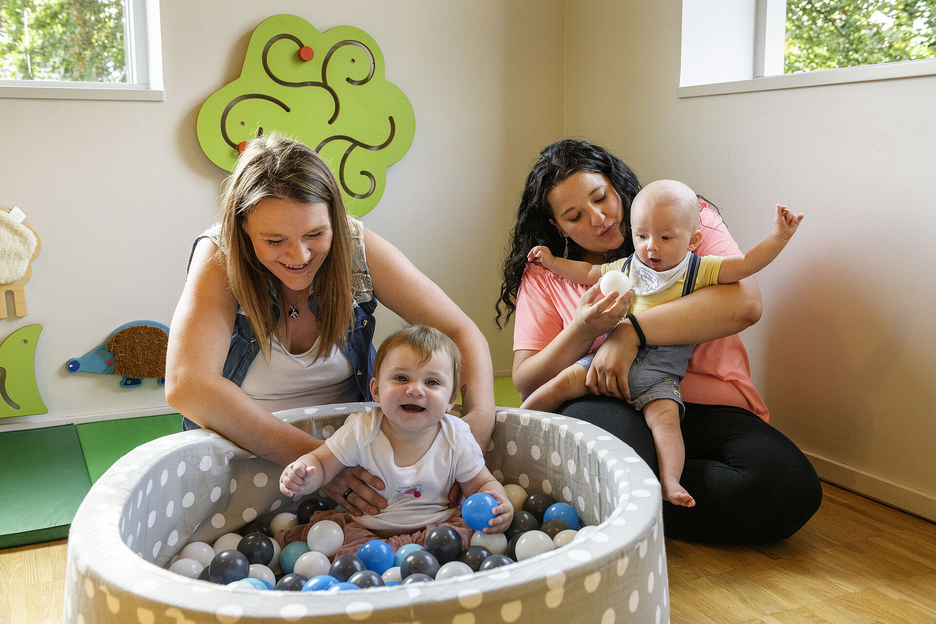 Mütter und ihre Kinder spielen im Bällebad