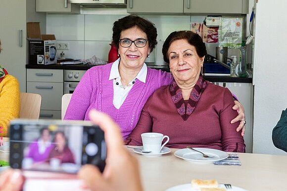 Zwei Damen umarmen sich im zentrum plus für ein Handyfoto 