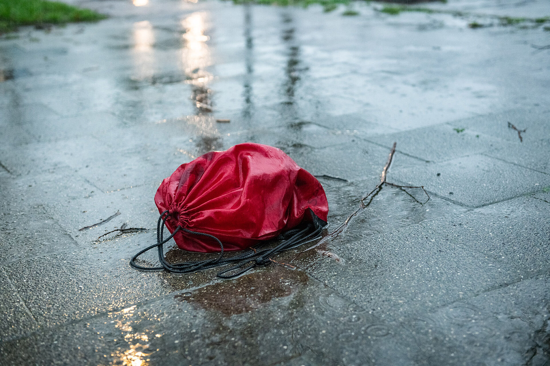 Ein Turnbeutel liegt auf nasser Straße