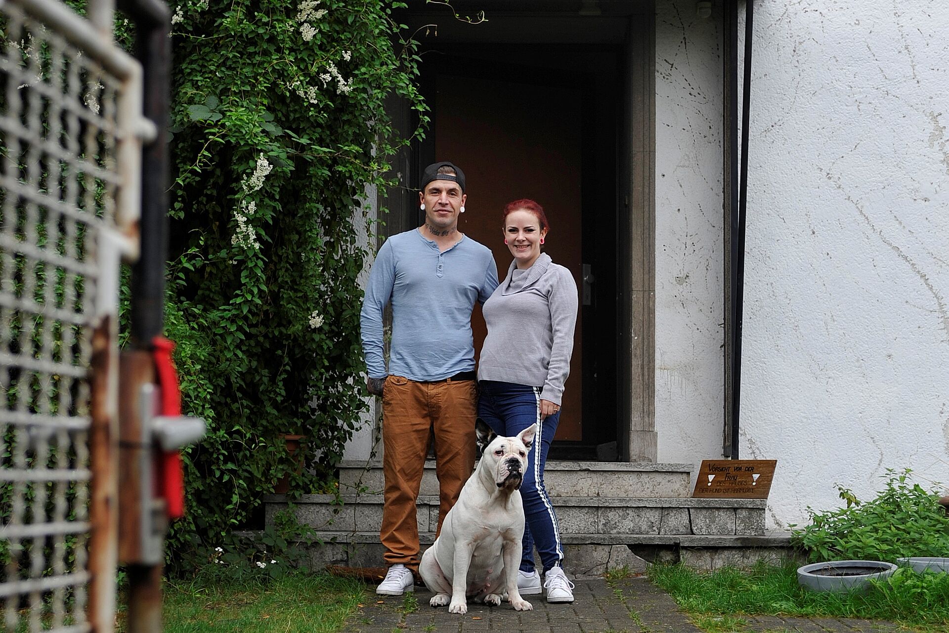 Ein ehemals wohnungsloses Paar steht vor der Tür seines neuen Zuhauses. 