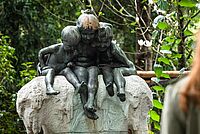Drei Bronzenfiguren auf einem Stein