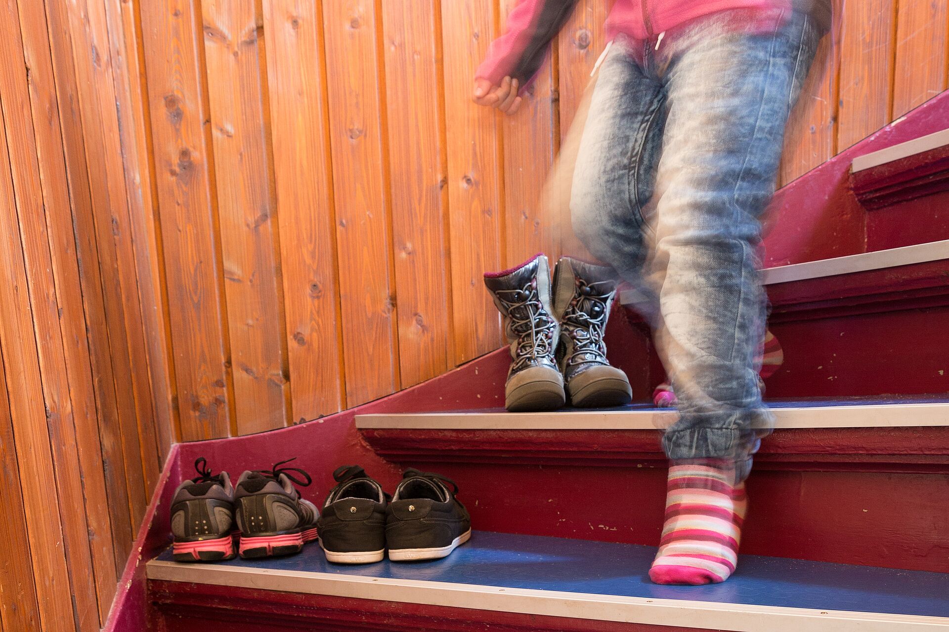 Ein Kind läuft auf Socken die Treppe hinunter. 