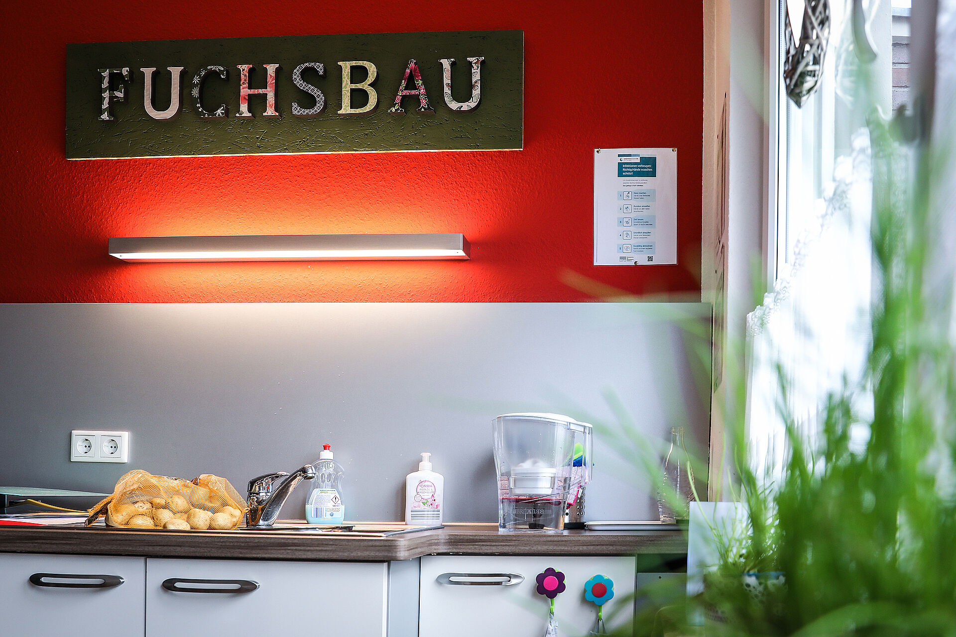 Der Schriftzug "Fuchsbau" an der Wand in der Küche der Wohngruppe "Füchse".