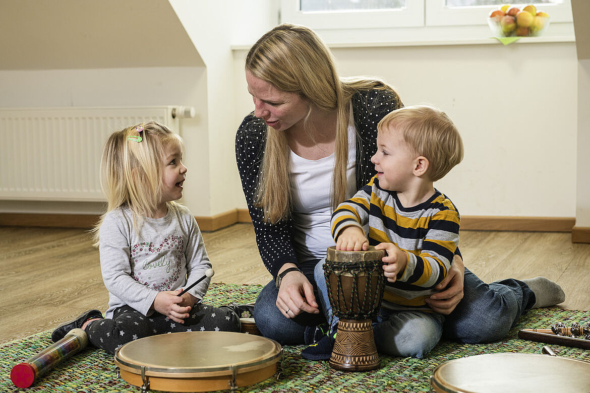 zwei Kinder machen Musik mit Mama
