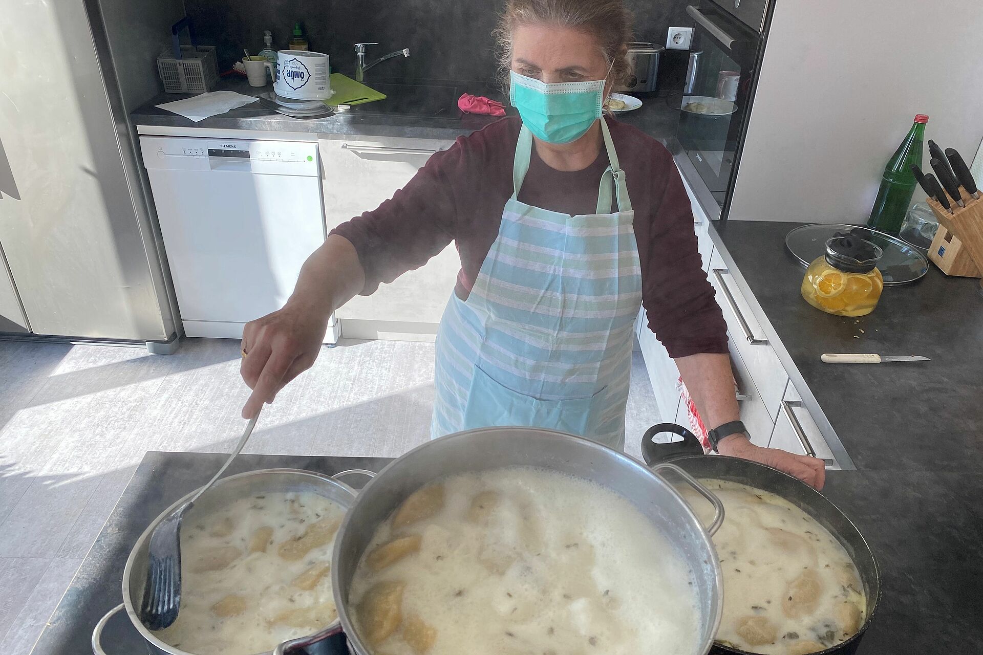 Frau mit drei Kochtöpfen